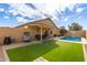 Inviting backyard oasis featuring a sparkling pool, patio furniture, and putting green at 3640 W Melinda Ln, Glendale, AZ 85308