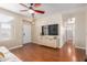 Bright living room with hardwood floors, a large TV, and a view into hallway at 3640 W Melinda Ln, Glendale, AZ 85308