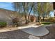 Private backyard showcasing a cozy patio, mature trees, and meticulously maintained desert landscaping at 40325 N Graham Way, Anthem, AZ 85086