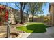 Lush backyard with a statue, artificial turf, and mature trees, creating a serene outdoor retreat at 40325 N Graham Way, Anthem, AZ 85086