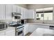 Gourmet kitchen with stainless steel Viking range, white cabinets, and plenty of counter space at 40325 N Graham Way, Anthem, AZ 85086