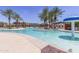 Large community pool with palm trees, lounge chairs, and a mushroom water feature at 41929 W Springtime Rd, Maricopa, AZ 85138