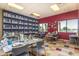 Bright craft room featuring tables, chairs, and a large shelving unit filled with ceramic pieces at 41929 W Springtime Rd, Maricopa, AZ 85138