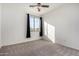 Bright bedroom with window, ceiling fan, and carpet at 44020 N 50Th Ln, New River, AZ 85087