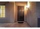 Dark brown front door with sidelights and a decorative doormat at 44020 N 50Th Ln, New River, AZ 85087