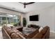 Spacious living room featuring a brown leather sectional sofa and large TV at 4765 S Pluto --, Mesa, AZ 85212