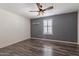 Bedroom with wood-look flooring, ceiling fan, and window shutters at 5172 E Desert Forest Trl, Cave Creek, AZ 85331