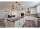 Modern kitchen with white cabinets, granite island, and stainless steel appliances at 5172 E Desert Forest Trl, Cave Creek, AZ 85331