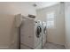 Bright laundry room with washer, dryer, and built-in shelving at 5172 E Desert Forest Trl, Cave Creek, AZ 85331