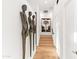 Hallway with a light-wood floor, modern art, and unique bronze statues lining the wall at 5724 N Echo Canyon Dr, Phoenix, AZ 85018