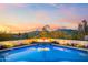 A tranquil pool with a fire feature and a picturesque mountain backdrop at sunset at 5724 N Echo Canyon Dr, Phoenix, AZ 85018