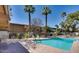 Refreshing community pool surrounded by palm trees and patio furniture at 6125 E Indian School Rd # 218, Scottsdale, AZ 85251