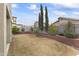 Landscaped backyard with grass, trees, and a retaining wall at 629 E Palo Verde St, Casa Grande, AZ 85122