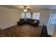 Living room with a black sectional sofa and large windows at 736 E Ivanhoe St, Chandler, AZ 85225