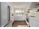 Modern white kitchen with quartz countertops, stainless steel appliances, and farmhouse sink at 7638 E Northland Dr, Scottsdale, AZ 85251