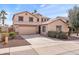 Two story house with a tan facade, two car garage, and landscaped yard at 8147 W Hilton Ave, Phoenix, AZ 85043