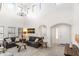 Spacious living room with high ceilings, gray sofas, and a large chandelier at 8147 W Hilton Ave, Phoenix, AZ 85043