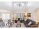 Bright living room with high ceilings, gray sofas, and a large chandelier at 8147 W Hilton Ave, Phoenix, AZ 85043