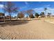 Sandy play area with trees and playground in background at 8147 W Hilton Ave, Phoenix, AZ 85043