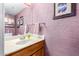 Clean bathroom with wood vanity, single sink, and mauve walls at 9183 W Century Dr, Arizona City, AZ 85123