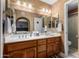 Double vanity bathroom with wood cabinets and updated lighting at 9183 W Century Dr, Arizona City, AZ 85123