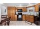 Bright kitchen featuring wood cabinets, black appliances, and a dining area at 9183 W Century Dr, Arizona City, AZ 85123