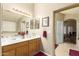 Bathroom featuring double sinks, wood cabinets, a walk-in shower, and neutral tile floors at 11163 W Edgemont Ave, Avondale, AZ 85392