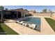 Inviting backyard pool with artificial grass, modern lounge chairs, and a charming shaded pergola at 1164 E Desert Rose Trl, San Tan Valley, AZ 85143