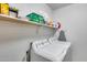 Laundry room with washer, dryer, and storage shelves at 13814 W Elm St, Surprise, AZ 85374