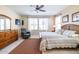 Main bedroom with a large bed, dresser, and a relaxing armchair at 16020 N 109Th Dr, Sun City, AZ 85351