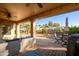 Covered patio with seating area, overlooking a desert landscaped backyard with a fire pit at 19751 N Desert Song Way, Surprise, AZ 85374