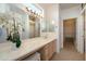 Bright bathroom with double vanity, large mirror, and walk-in closet at 19751 N Desert Song Way, Surprise, AZ 85374