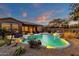 Expansive backyard oasis featuring a sparkling pool, lush landscaping, and a fire pit at 19771 N 84Th Way, Scottsdale, AZ 85255
