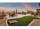 Artificial turf backyard with cornhole and outdoor kitchen at 19771 N 84Th Way, Scottsdale, AZ 85255