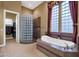Luxurious bathroom with a soaking tub, walk-in shower, and glass block accents at 19771 N 84Th Way, Scottsdale, AZ 85255