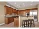 Gourmet kitchen featuring wood cabinetry, granite counters, and breakfast bar at 19771 N 84Th Way, Scottsdale, AZ 85255