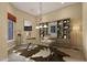 Well-lit office space with custom built-ins, a large desk with a unique rug, and a cozy chair at 19771 N 84Th Way, Scottsdale, AZ 85255