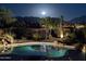 Backyard pool with a view of the mountains under a full moon at night at 19771 N 84Th Way, Scottsdale, AZ 85255