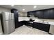 Updated kitchen features stainless steel appliances, a refrigerator, black cabinets, and light countertops at 1983 E Don Carlos Ave, Tempe, AZ 85281