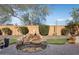 Serene backyard with a stone waterfall feature and lush landscaping at 26788 W Yukon Dr, Buckeye, AZ 85396