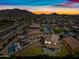 Sunset aerial view of a home with a pool in a vibrant neighborhood setting with mountain backdrop at 2776 E Mews Rd, Gilbert, AZ 85298