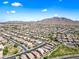 Expansive aerial view of a desert community with mountain views under a clear blue sky, showcasing the neighborhood's layout at 2776 E Mews Rd, Gilbert, AZ 85298