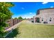 Expansive backyard showcasing a lush green lawn, a covered patio, and a neutral-colored exterior at 2776 E Mews Rd, Gilbert, AZ 85298