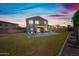Expansive backyard with a covered patio, lush lawn, and stylish lighting, perfect for outdoor gatherings and relaxation at 2776 E Mews Rd, Gilbert, AZ 85298