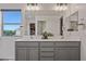Stylish bathroom features double sinks with gray cabinets, a large mirror, and a window for natural light at 2776 E Mews Rd, Gilbert, AZ 85298