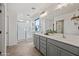 Bathroom featuring double sinks, gray cabinets, and a glass-enclosed shower for a modern and luxurious feel at 2776 E Mews Rd, Gilbert, AZ 85298