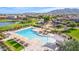 Resort-style community pool with shaded lounge areas, playground, and lake access surrounded by lush landscaping at 2776 E Mews Rd, Gilbert, AZ 85298