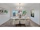 Elegant dining room with modern chandelier, neutral decor, tile floors, and windows looking out to the backyard at 2776 E Mews Rd, Gilbert, AZ 85298