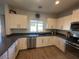 Modern kitchen with white cabinets, dark countertops, and stainless steel appliances at 2776 E Mews Rd, Gilbert, AZ 85298