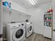 Functional laundry room with washer and dryer, shelving for storage, and modern appliances, designed for convenience at 2776 E Mews Rd, Gilbert, AZ 85298